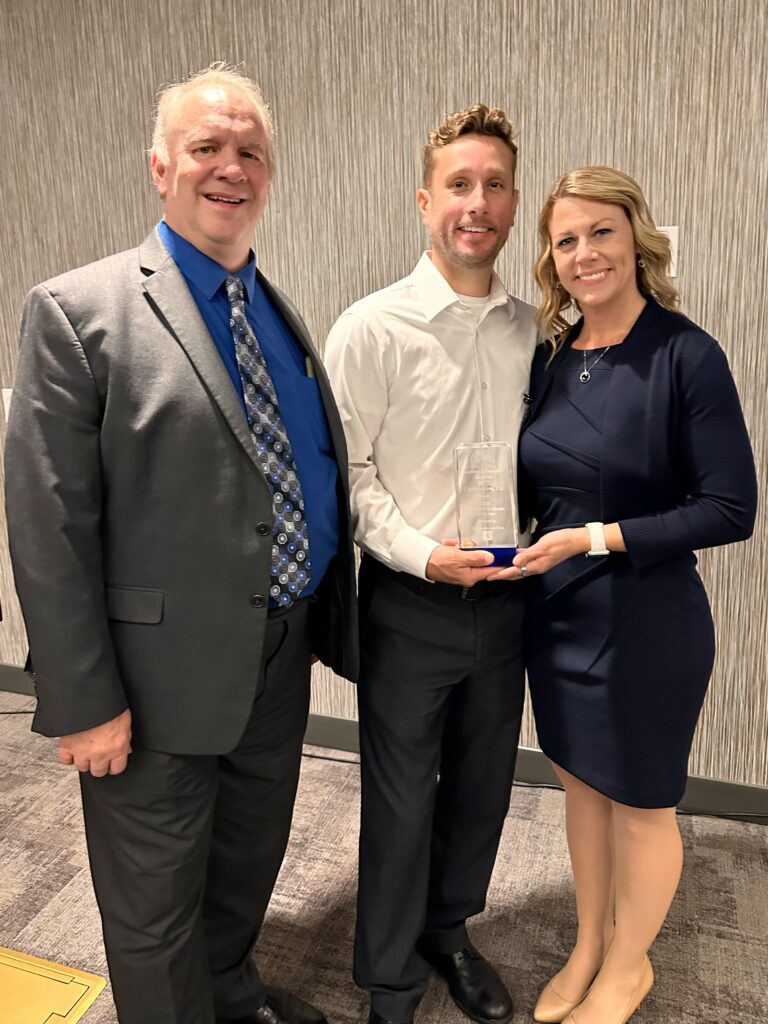 Adam & Lori Bryant of HTZ Construction winning the Richfield Chamber of Commerce 2023 Business of the Year award, presented by Jim Koewler of Koewler Law